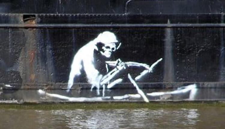 One of the darker of Bankys paintings is near the M-Shed Museum and harbourside, of The Grim Reaper. The white hooded figure is rowing a boat displayed outside the Bristol Life Gallery. It used to be on the side of a former cargo ship known as the Thekla, which was moored in the harbour.  It was too exposed to the elements and was deteriorating rapidly. It is now on a long-term loan to M-Shed